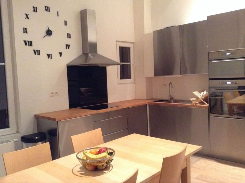 Fully equipped kitchen with oven, hob, extractor hood and a wooden dining table seating four