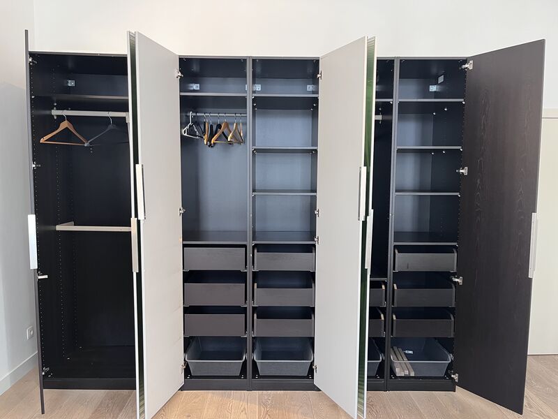 Open wardrobe showing hanging rails, shelves and drawers offering ample storage for long stays