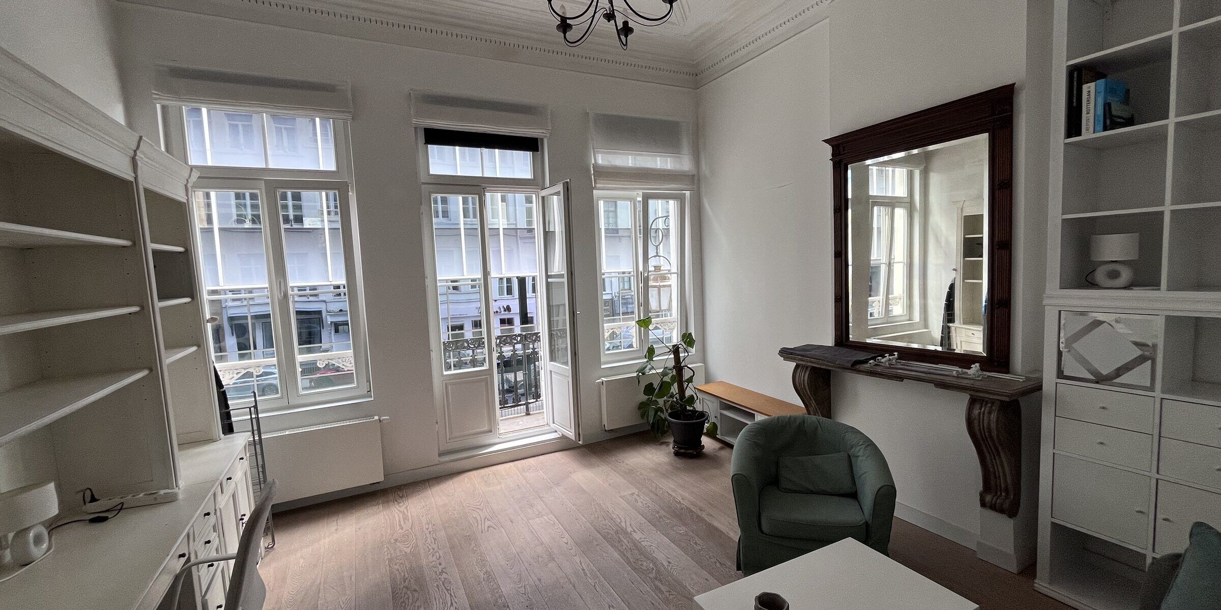 Bright living room with marble fireplace and bay window in the Brussels Grand Place apartment
