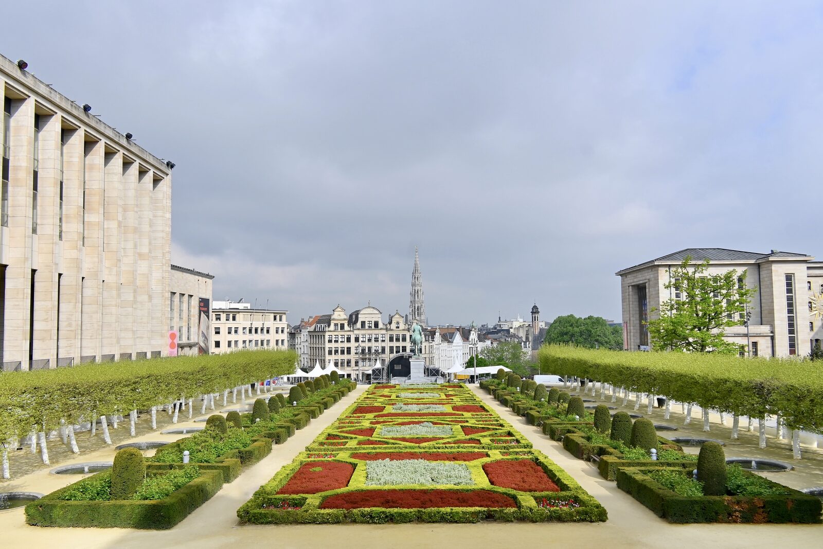 The formal garden of the Mont des Arts in Brussels seen from above, with clipped hedges and flowerbeds leading down towards the city