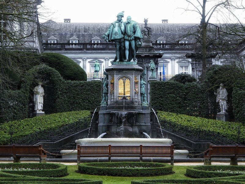 The Egmont and Hoorn monument in the Square du Petit Sablon in Brussels, water falling from the plinth into a stone basin, with clipped hedges and bronze statuettes on either side