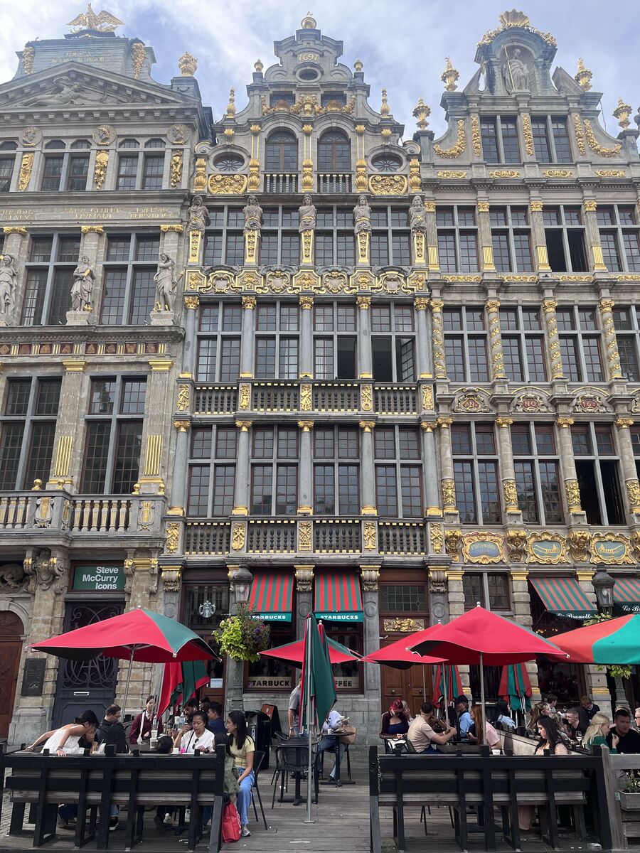 Le Sac in the north-west row of the Grand-Place, its balustraded first floor and gilded window frames above a café at street level, with La Brouette to the right.