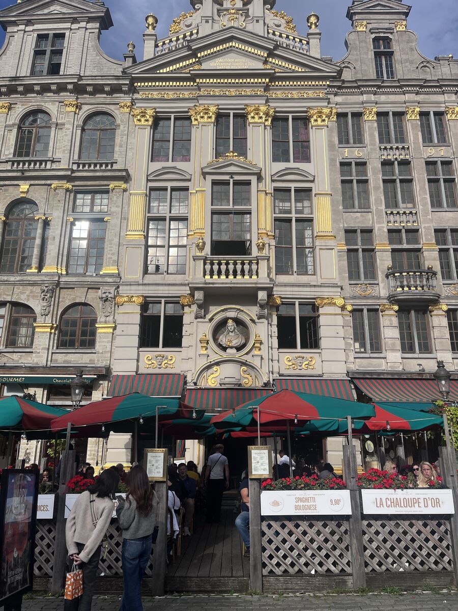 La Chaloupe d'Or on the Grand-Place, a bust set in a round medallion at the centre of its gilded facade above the restaurant's terrace.